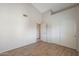 Empty bedroom with wood-look flooring, white closet doors, and neutral walls at 6123 W Grandview Rd, Glendale, AZ 85306