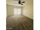 Spacious living room with carpet, ceiling fan, and sliding glass doors at 6818 N 35Th Ave # J, Phoenix, AZ 85017