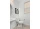 Powder room featuring pedestal sink, toilet, and modern wall decor at 11003 E Tesla Ave, Mesa, AZ 85212