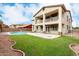 Backyard oasis with a pool, grassy area, and a balcony overlooking it at 15835 W Desert Mirage Dr, Surprise, AZ 85379