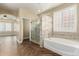 Inviting bathroom with a glass shower, soaking tub, and tiled walls at 15835 W Desert Mirage Dr, Surprise, AZ 85379