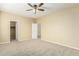 Comfortable bedroom with carpeted flooring, a ceiling fan, and closet access at 15835 W Desert Mirage Dr, Surprise, AZ 85379