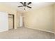 Spacious, unfurnished bedroom with ceiling fan, closet, and carpeted floors at 15835 W Desert Mirage Dr, Surprise, AZ 85379