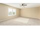 Spacious bedroom with carpet flooring, ceiling fan, and plantation shutters at 15835 W Desert Mirage Dr, Surprise, AZ 85379
