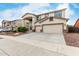 Tan two-story home with a covered entryway and a three-car garage at 15835 W Desert Mirage Dr, Surprise, AZ 85379