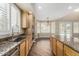 Kitchen with stainless steel sink, wood cabinets, granite countertops, and view of the pool at 15835 W Desert Mirage Dr, Surprise, AZ 85379