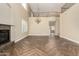 Living area with high ceilings, wood-look tile floors, fireplace, and view of balcony at 15835 W Desert Mirage Dr, Surprise, AZ 85379