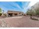 Large backyard featuring a covered patio, desert landscaping, and mature trees at 17994 N Verde Roca Dr, Surprise, AZ 85374