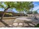 Landscaped backyard with a paver walkway, shade trees, and a water feature at 2957 E Melrose St, Gilbert, AZ 85297