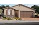 Exterior elevation of a single-story home with a two-car garage and landscaped front yard at 8657 W Warner St, Tolleson, AZ 85353