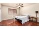 Cozy bedroom with wood floors, ceiling fan, and a window with blinds at 10330 W Desert Forest Cir, Sun City, AZ 85351