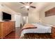 Bedroom featuring ceiling fan, wooden dresser, hardwood flooring, and walk-in closet at 10330 W Desert Forest Cir, Sun City, AZ 85351