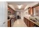 Kitchen with stainless steel appliances, granite countertops, wood cabinetry, and tile flooring at 10330 W Desert Forest Cir, Sun City, AZ 85351