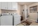 Practical laundry room equipped with a washer, dryer, and storage cabinets at 10330 W Desert Forest Cir, Sun City, AZ 85351