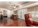 Living room with wood flooring, ceiling fan, access to a bedroom, and patio doors at 10330 W Desert Forest Cir, Sun City, AZ 85351
