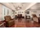 Living area with wood-look flooring, a ceiling fan, and sliding glass doors at 10330 W Desert Forest Cir, Sun City, AZ 85351