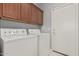 Laundry room with washer, dryer, and cabinets at 13137 W Stella Ln, Litchfield Park, AZ 85340