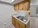 Kitchen sink area with stainless steel double sink and light wood cabinetry at 1433 N 53Rd Ave, Phoenix, AZ 85043