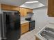 Kitchen featuring black appliances, wood cabinets, and tile flooring at 1433 N 53Rd Ave, Phoenix, AZ 85043