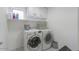 Bright laundry room with washer, dryer, and overhead storage at 19776 N Harris N Dr, Maricopa, AZ 85138