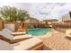 Sparkling pool with a rock waterfall feature, lounge chairs, and patio space at 25847 W Ripple Rd, Buckeye, AZ 85326