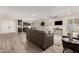 Open living room with wood-look tile flooring, a ceiling fan, and views of the dining area and kitchen at 26201 S Sherbrook Dr, Sun Lakes, AZ 85248