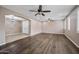 Open living room with wood flooring, arched entryway, and ceiling fans at 2872 E Redwood Pl, Chandler, AZ 85286