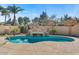 Backyard with a pool, rock waterfall feature, and lush landscaping at 2981 E Fandango Dr, Gilbert, AZ 85298