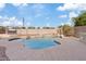 Inviting pool and patio area with decorative rocks, landscaping, and a clear blue sky at 3112 W Pleasant Ln, Phoenix, AZ 85041