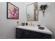 Bathroom with dark blue vanity, gold fixtures, and decorative mirror at 33296 N Vanishing Trl, Scottsdale, AZ 85266