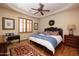 Spacious bedroom with wood flooring, ceiling fan, and plush carpeting at 33296 N Vanishing Trl, Scottsdale, AZ 85266