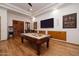 Game room with pool table, built-in cabinets, and wood floors at 33296 N Vanishing Trl, Scottsdale, AZ 85266