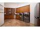 Laundry room with wood cabinets, washer, dryer, and tile floors at 33296 N Vanishing Trl, Scottsdale, AZ 85266