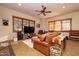 Cozy living room with leather couch, TV, and large windows at 33296 N Vanishing Trl, Scottsdale, AZ 85266