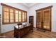 Home office with wood desk, plantation shutters, and wood floors at 33296 N Vanishing Trl, Scottsdale, AZ 85266