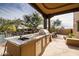 Outdoor kitchen area with granite counters, built-in grill, and sink at 33296 N Vanishing Trl, Scottsdale, AZ 85266