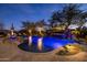 Inviting pool with rock waterfall and spa, illuminated at twilight at 33296 N Vanishing Trl, Scottsdale, AZ 85266