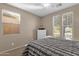 Bedroom featuring a bed, white dresser and nightstands, ceiling fan, and multiple windows at 4627 E Jude Ln, Gilbert, AZ 85298