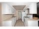 Bright galley kitchen with white cabinets, light countertops, and white appliances at 4905 S Willow Dr, Tempe, AZ 85282