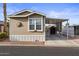 Tan single-wide manufactured home with carport and storage shed at 8865 E Baseline Rd # 1129, Mesa, AZ 85209