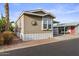 Tan single-wide manufactured home with carport, landscaping, and golf cart at 8865 E Baseline Rd # 1129, Mesa, AZ 85209
