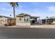 Tan single-wide manufactured home with carport and partial view of neighbor's home at 8865 E Baseline Rd # 1129, Mesa, AZ 85209