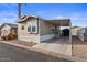 Tan single-wide manufactured home with carport and storage shed at 8865 E Baseline Rd # 1129, Mesa, AZ 85209