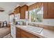 Kitchen with wood cabinets, double sink, and view of dining area at 8865 E Baseline Rd # 1129, Mesa, AZ 85209
