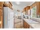 Long kitchen with wood cabinets, white appliances, and tile floor at 8865 E Baseline Rd # 1129, Mesa, AZ 85209
