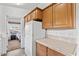 Kitchen with wood cabinets, white refrigerator, and view into bedroom at 8865 E Baseline Rd # 1129, Mesa, AZ 85209