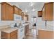 Galley kitchen with wood cabinets, white appliances, and tile floor at 8865 E Baseline Rd # 1129, Mesa, AZ 85209