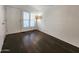 Bright living area with dark wood-look flooring, white walls, and a tripod lamp at 9333 E University Dr # 48, Mesa, AZ 85207