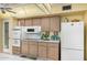 Kitchen featuring wood cabinetry, white appliances, and ample counter space at 10202 W Mountain View Rd, Sun City, AZ 85351