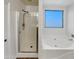 Bathroom with shower, bathtub, and window providing natural light at 11214 W Rio Vista Ln, Avondale, AZ 85323